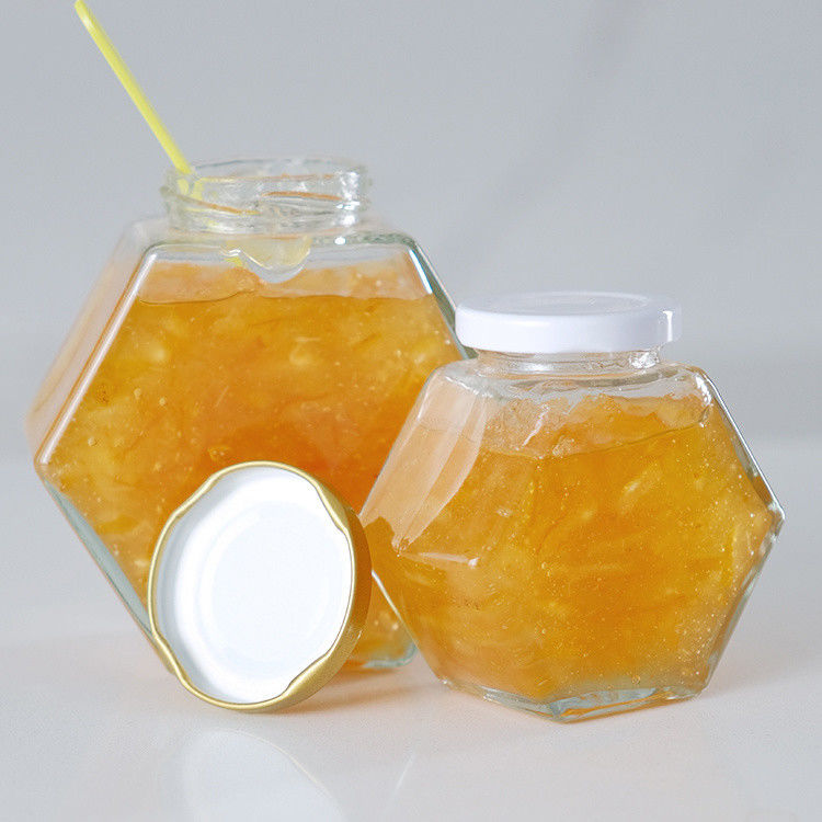 Hexágono espesado Transparente Almacenamiento de alimentos de diferentes tamaños Jarrones de vidrio de miel con tapas de metal selladas