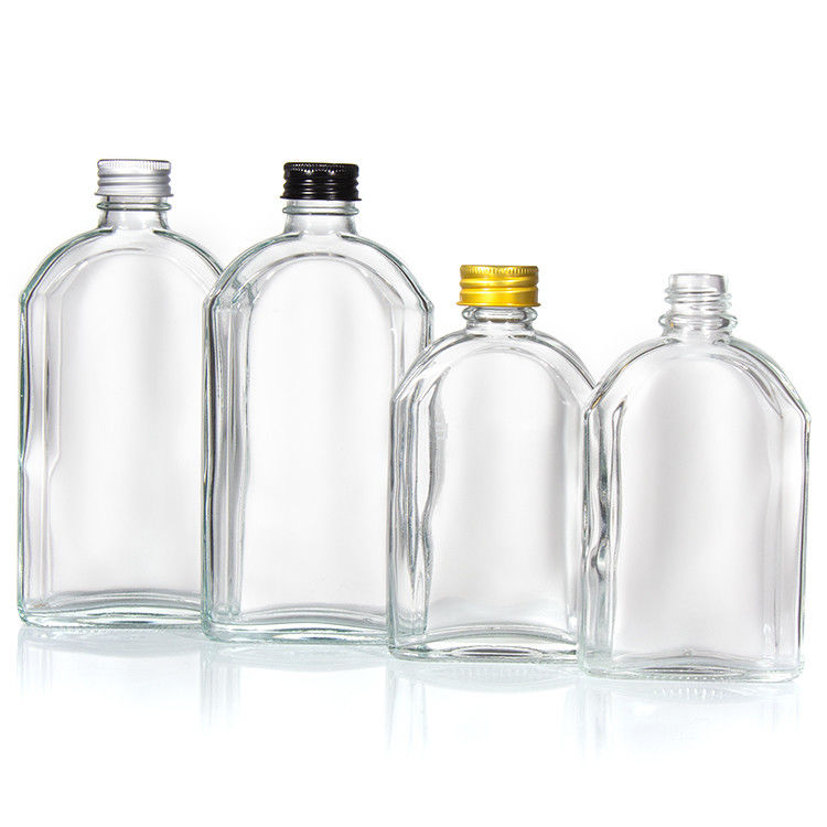 Botella plana de vidrio de licor transparente con tapa de aluminio